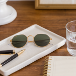Notepad, pen, sunglasses and water on table—props for women investors exploring cryptocurrency.