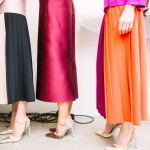 Women in feminine, elegant and colourful attire, queuing to access economic power.