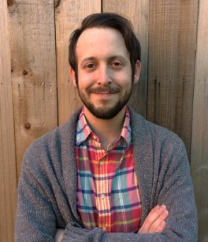 A portrait of Jeff Guenther, known as the therapy Jeff, wearing a chequered shirt and leaning against a wooden wall -introducing the December–January Curated Letter, curated to build confidence and help you become the most interesting woman in the room.