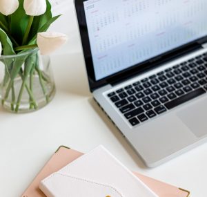 A laptop, a notebook on a desk, picturing the use of Chat GPT in Finance, empowering women investors- arisky revolution